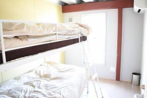 上段が茶色基調で下段が白色基調の2段ベッドが備え付けられている宿泊部屋の写真