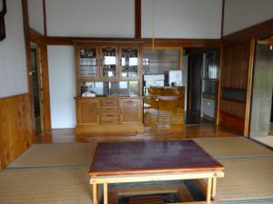 茶の間の写真。茶色のローテーブルが置かれた和室で、食器棚が置かれている。