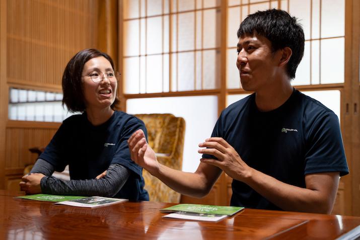 秋山さん夫妻が和室で横並びに座りながらインタビューに答えている様子の写真