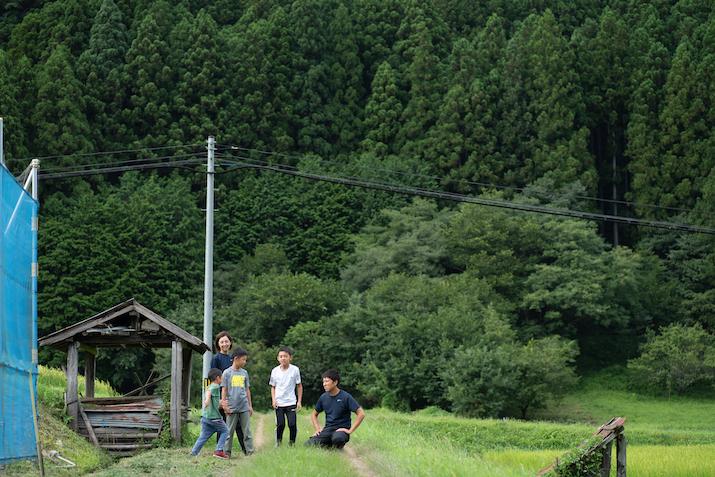 山を背に秋山さんの家族が談笑している写真